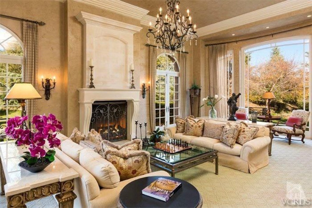 The formal living room with a focal fireplace and long narrowed windows. 