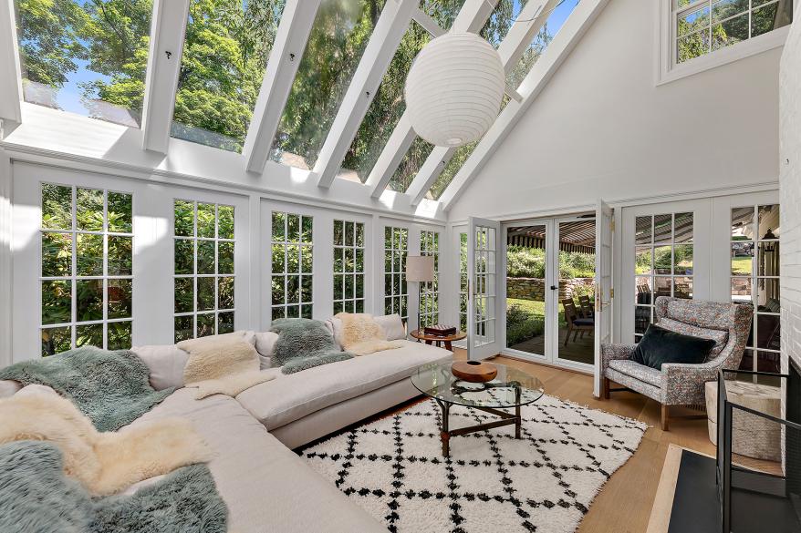A two-story sunroom floods the space with natural light.