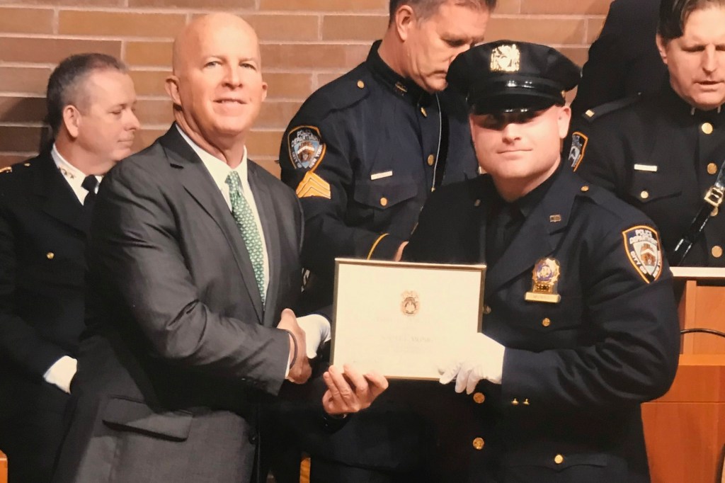 Detective Scott Munro Jr. (left) is presented an award by former New York City Police Commissioner James O'Neill