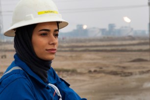 Ayat Rawthan, a petrochemical engineer, poses for a photo near an oil field outside Basra, Iraq, Tuesday, Feb. 5, 2021.