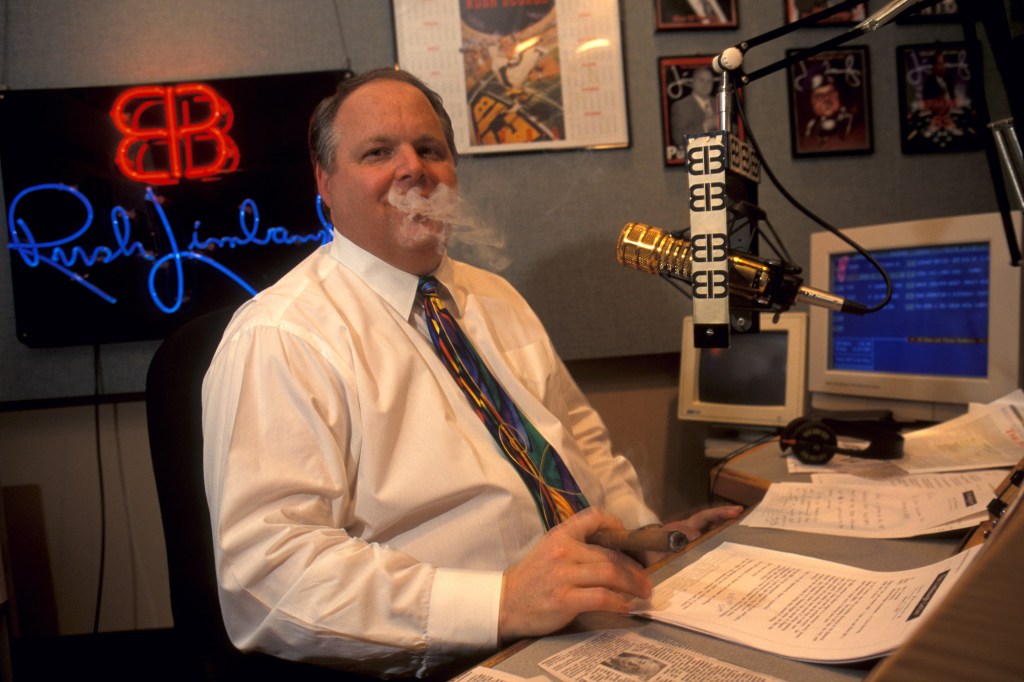 Conservative radio talk show host Rush Limbaugh takes a break and smokes a cigar during his radio show.