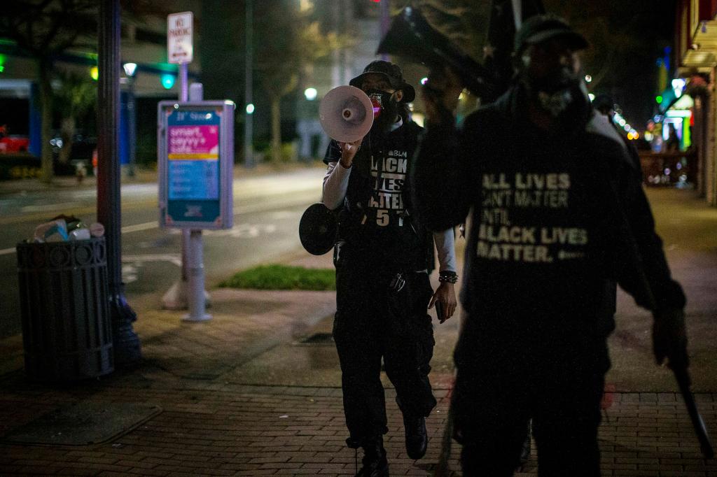 Aubrey "Japharii" Jones, left, walks on the sidewalk on Atlantic Ave. Saturday March 27, 2021 in Virginia Beach, Va.. Overnight shootings near the Atlantic oceanfront in Virginia Beach.