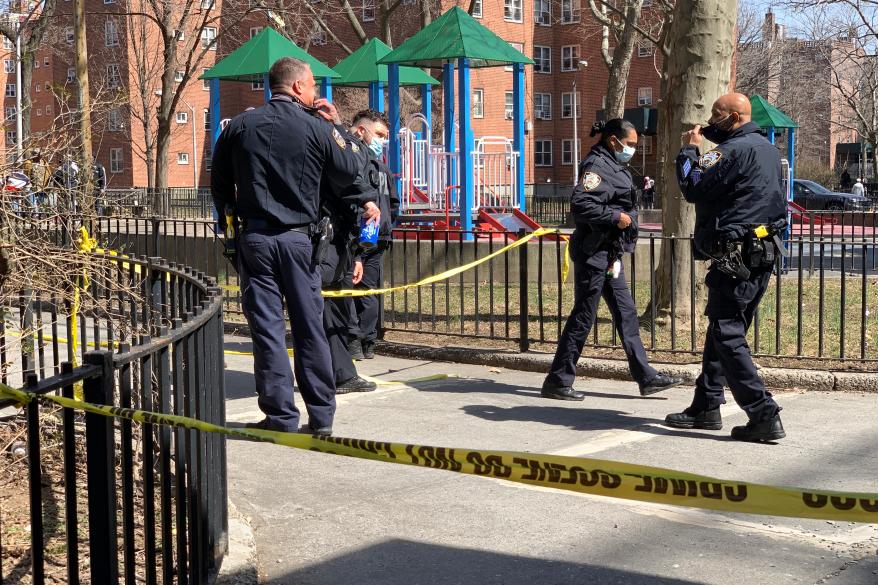 Police investigate the scene near where a man was shot dead Tuesday outside of a NYCHA housing complex near 49th Street and Broadway in Queens.
