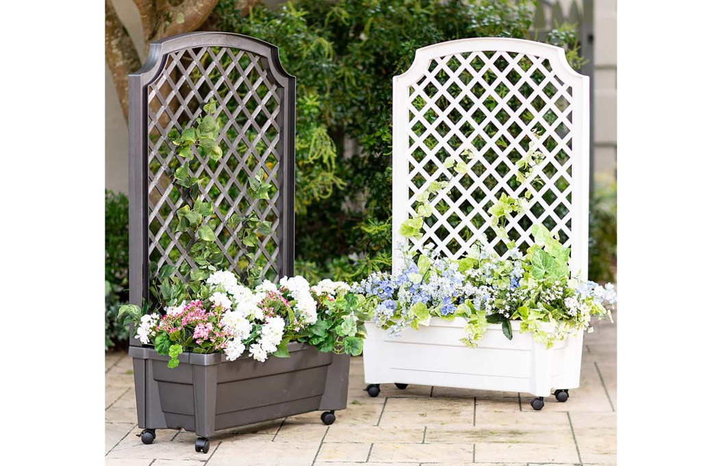 Two stand up planters, one white and one brown, with flowers in the bed 