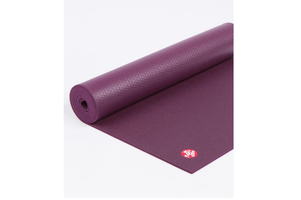 A dark purple yoga mat rolled up 