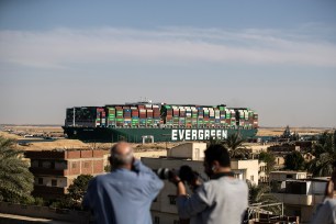 People watch as the container ship 'Ever Given' is refloated, unblocking the Suez Canal on March 29, 2021 in Suez, Egypt.