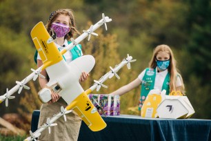 Girl Scouts Alice, right, and Gracie pose with a Wing delivery drone in Christiansburg, Va.