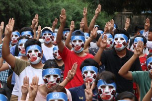 Young demonstrators flash the three-fingered symbol of resistance during an anti-coup mask strike in Yangon, Myanmar, Sunday, April 4, 2021.