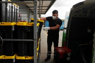 A worker removes containers with used supplies from vaccines and protective equipment.