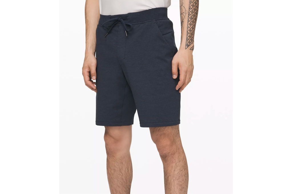 A man's lower body in navy blue shorts 