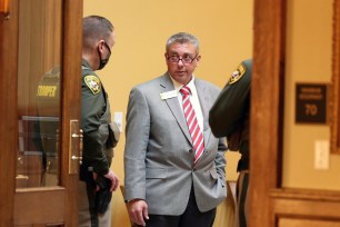 Wyoming state Sen. Anthony Bouchard chats with state troopers during a virtual legislation session inside the Senate chamber in Cheyenne, Wyoming on Jan. 12, 2021.