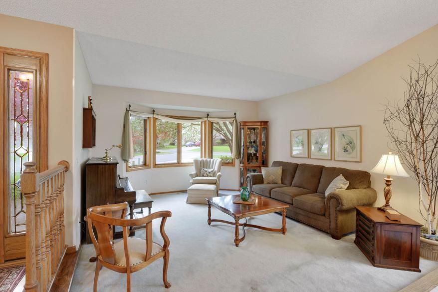 The front living room has bay windows and an upright piano.