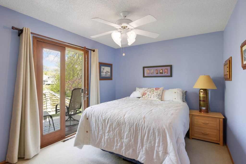This blue bedroom has a balcony overlooking the back porch.