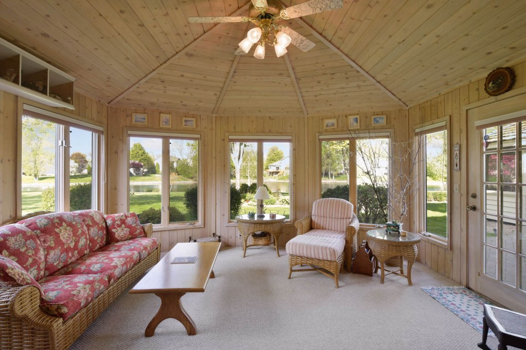 The sun room looks over the 0.77-acre lot with a gazebo.