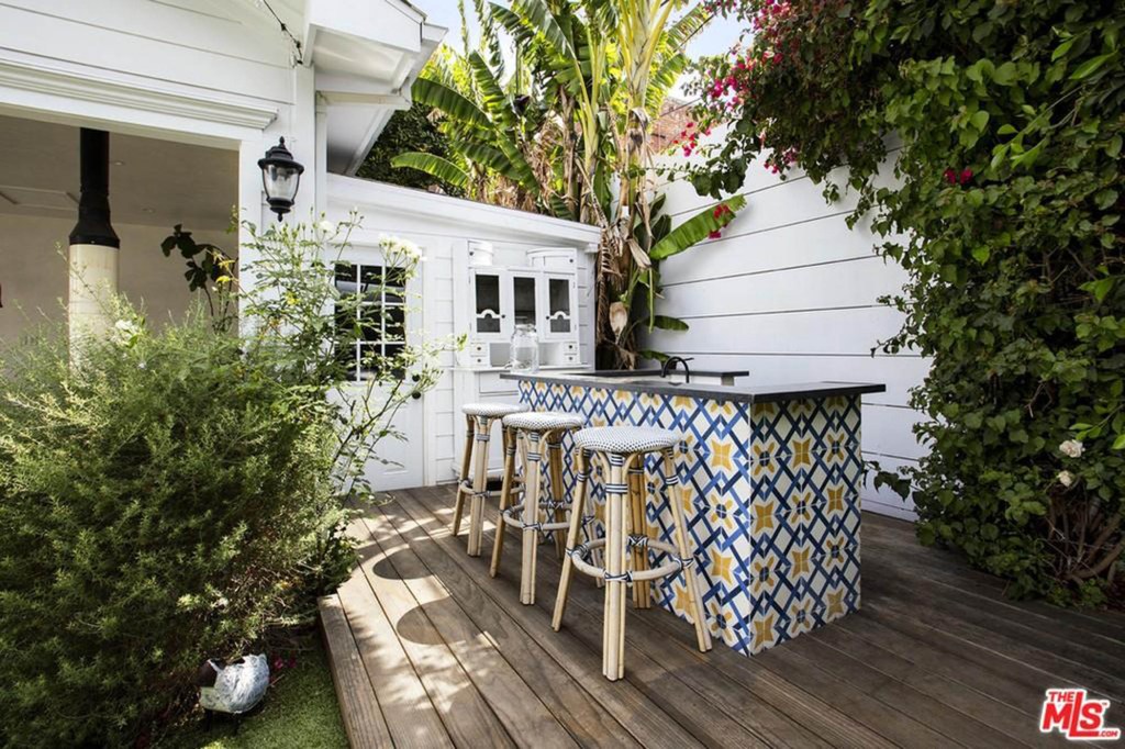 A small patio behind the cabana has a tile-accented bar.