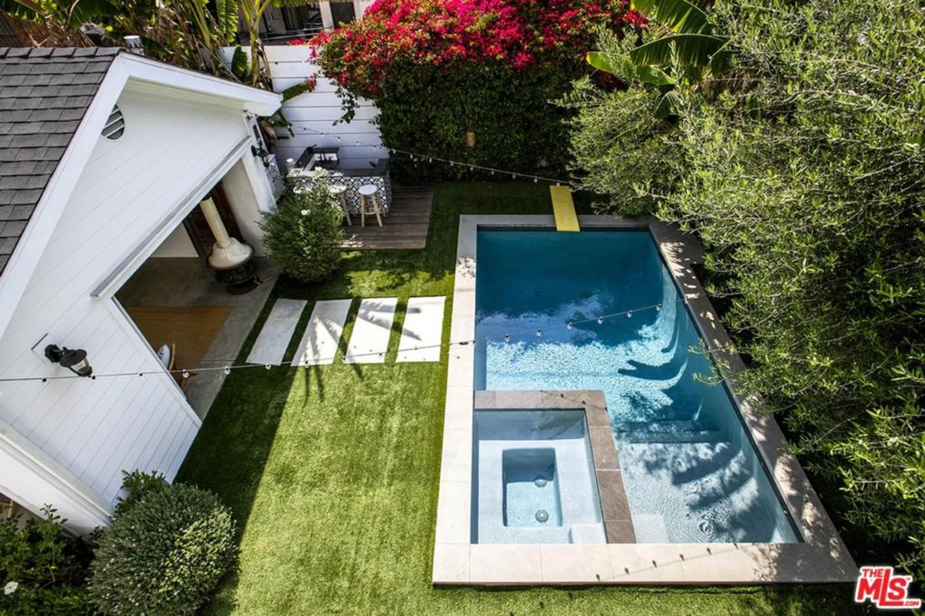 The detached two-car garage has been converted to an open-air cabana alongside the swimming pool and spa.