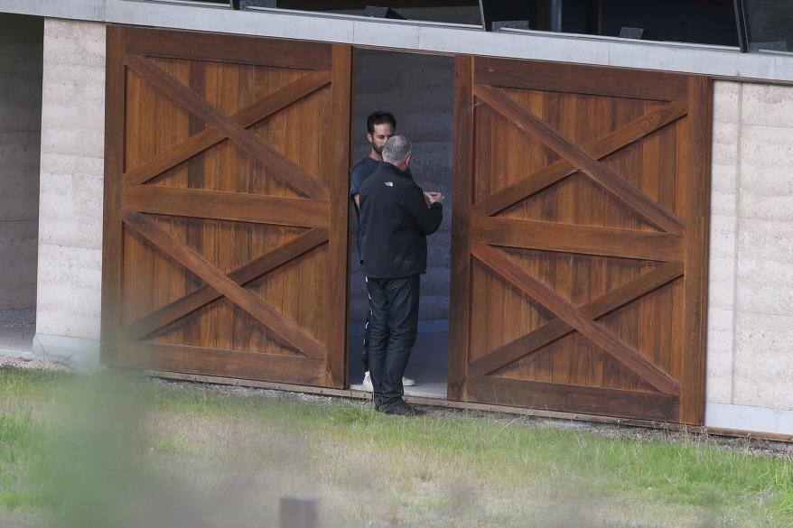 Millepied and the architect stand at the house's large wooden sliding barn doors.