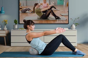 A woman does crunches mimicking a work out video