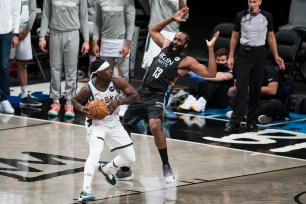 Milwaukee Bucks guard Jrue Holiday (21) drives into Brooklyn Nets guard James Harden (13)