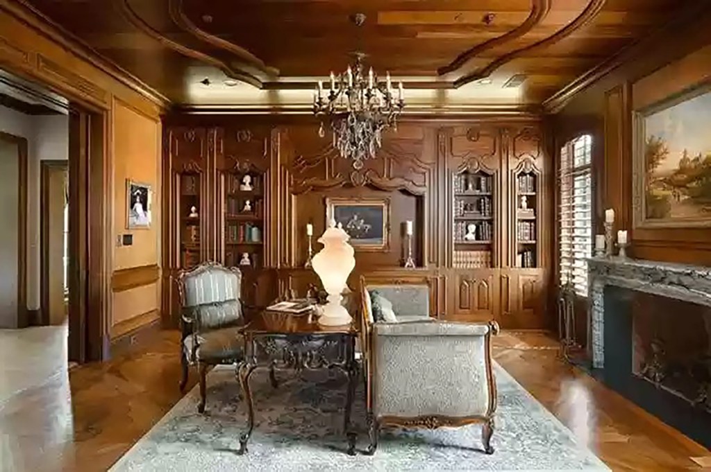 The wood-paneled study has a wood-burning fireplace.