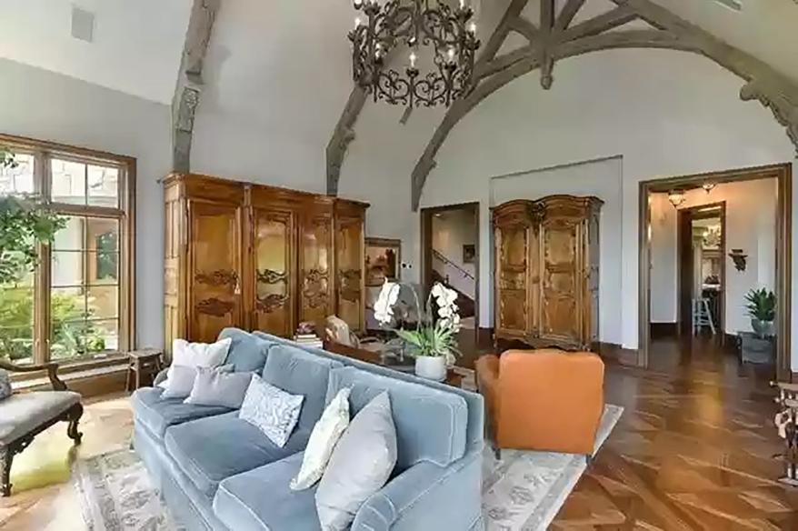 The family room still features an imposing stone fireplace, soaring cathedral ceilings and exposed ceiling beams, photos show.