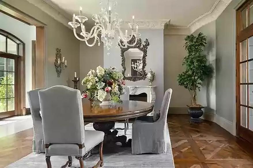 A formal dining room with a chandelier and a fireplace is pictured.