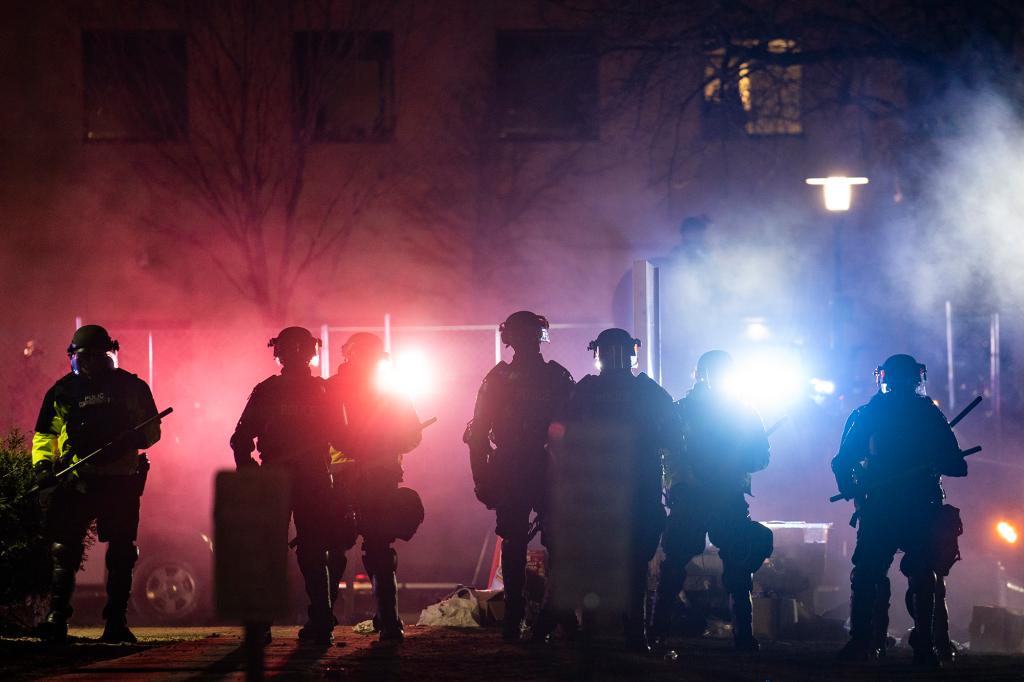 Law enforcement officers clear an area of demonstrators during a protest over Sunday's fatal shooting of Daunte Wright during a traffic stop, outside the Brooklyn Center Police Department in Brooklyn Center, Minn.