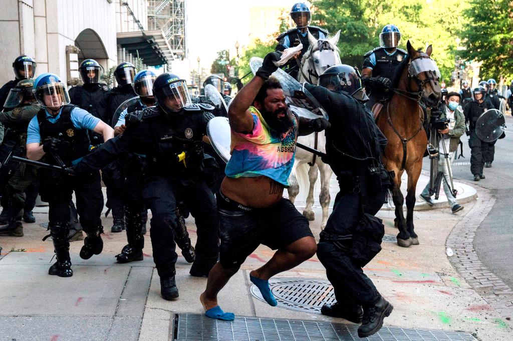 Riot police chase a man as they rush protestors to clear Lafayette Park and the area around it across from the White House for President Donald Trump to be able to walk through for a photo opportunity in front of St. John's Episcopal Church, during a rally against the death in Minneapolis police custody of George Floyd, near the White House, in Washington, U.S. June 1, 2020.