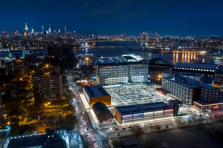 A bird's-eye view shows the Brooklyn Navy Yard area at night.