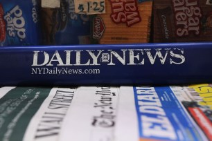 Photo of a newsstand with papers, including the New York Daily News.