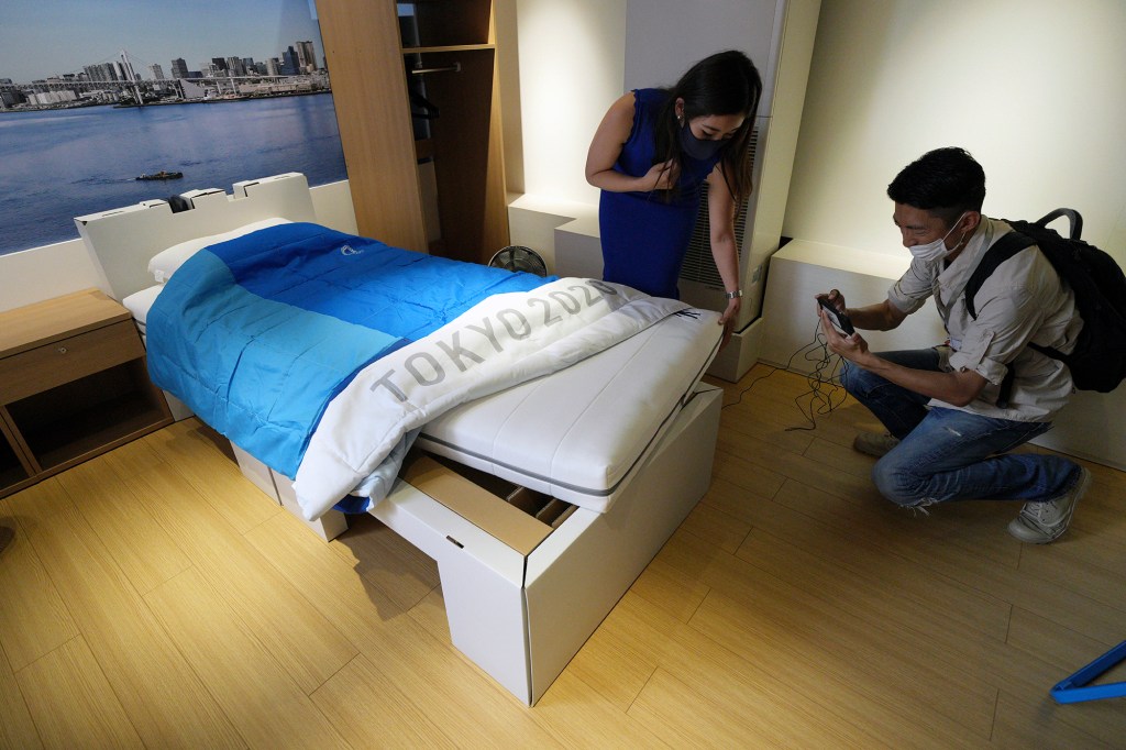 Journalists take photos of the cardboard beds for athletes at the Tokyo Olympics.