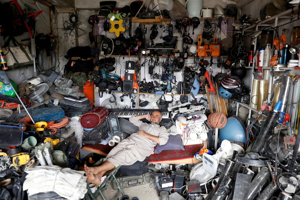 An Afghan man rests in his shop as he sell U.S. second hand materials outside Bagram U.S. air base