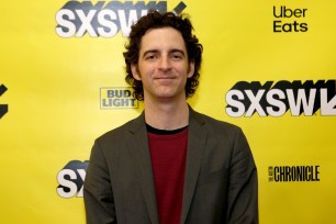 Zack O'Malley Greenburg standing in front of "step-and-repeat" background for SXSW