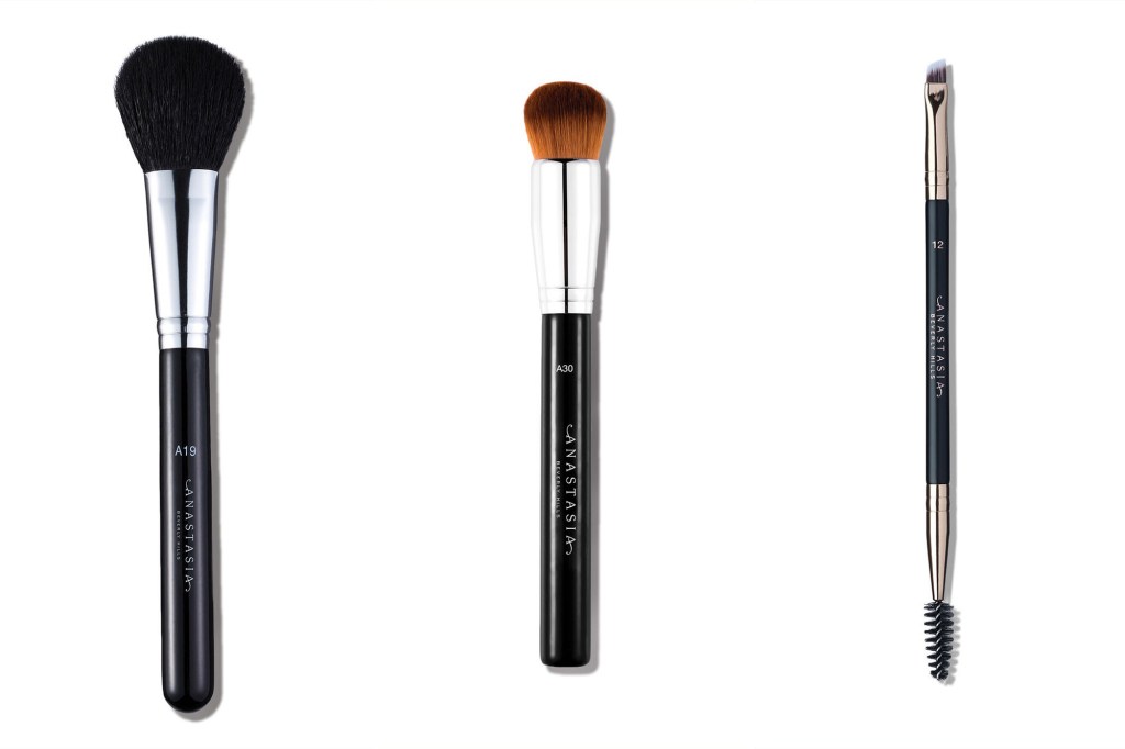 Three makeup brushes lined up next to each other on white background