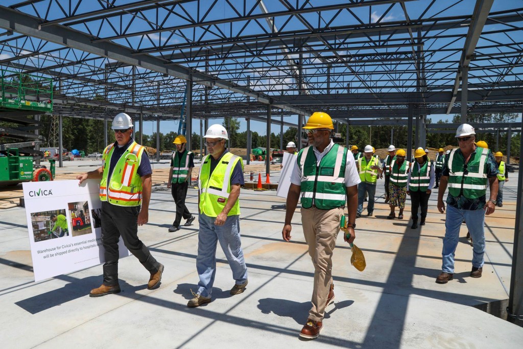 In this June 23, 2021 photo provided by Civica Rx, foreground from left, Jason Winfield and Martin VanTrieste of Civica Rx and Petersburg Mayor Sam Pelham tour the construction site of the company's Essential Medicines Manufacturing Facility in Petersburg, Va.