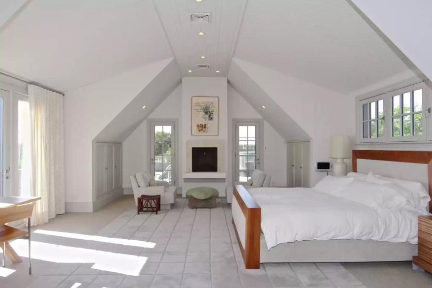 One of the home's seven bedrooms, this one with peaked ceilings, is pictured.