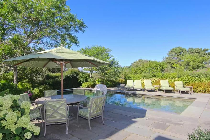 The stone patio with a pool is pictured.