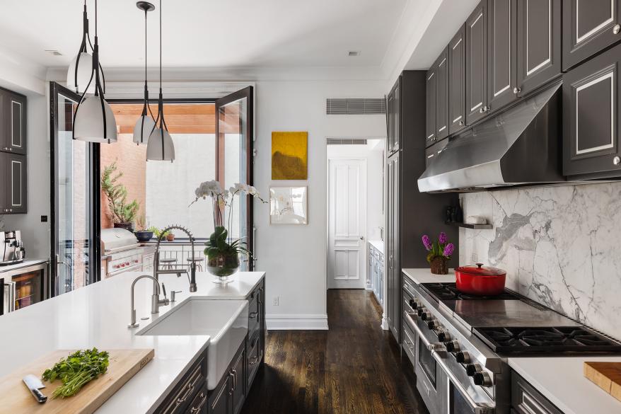 The kitchen has a pantry, cabinets, Caesarstone countertops and a marble backsplash.