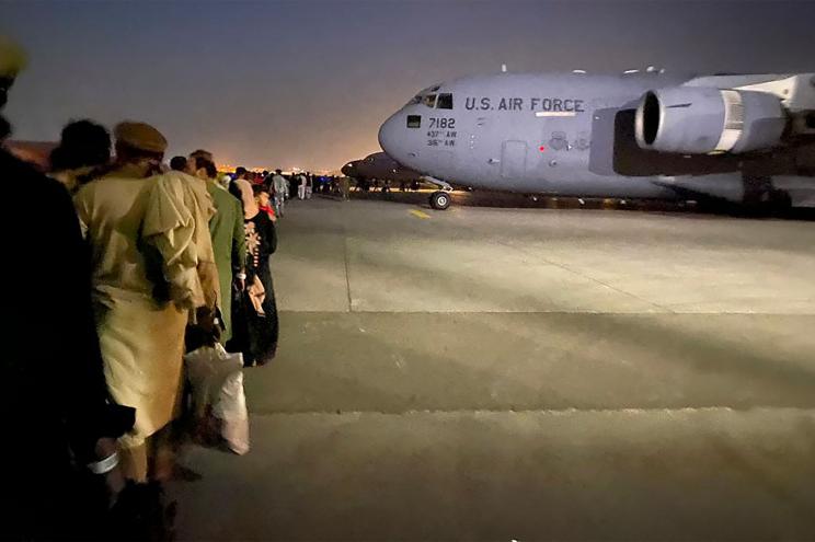 Afghan people queue up and board a U S military aircraft to leave Afghanistan, at the military airport in Kabul on August 19, 2021