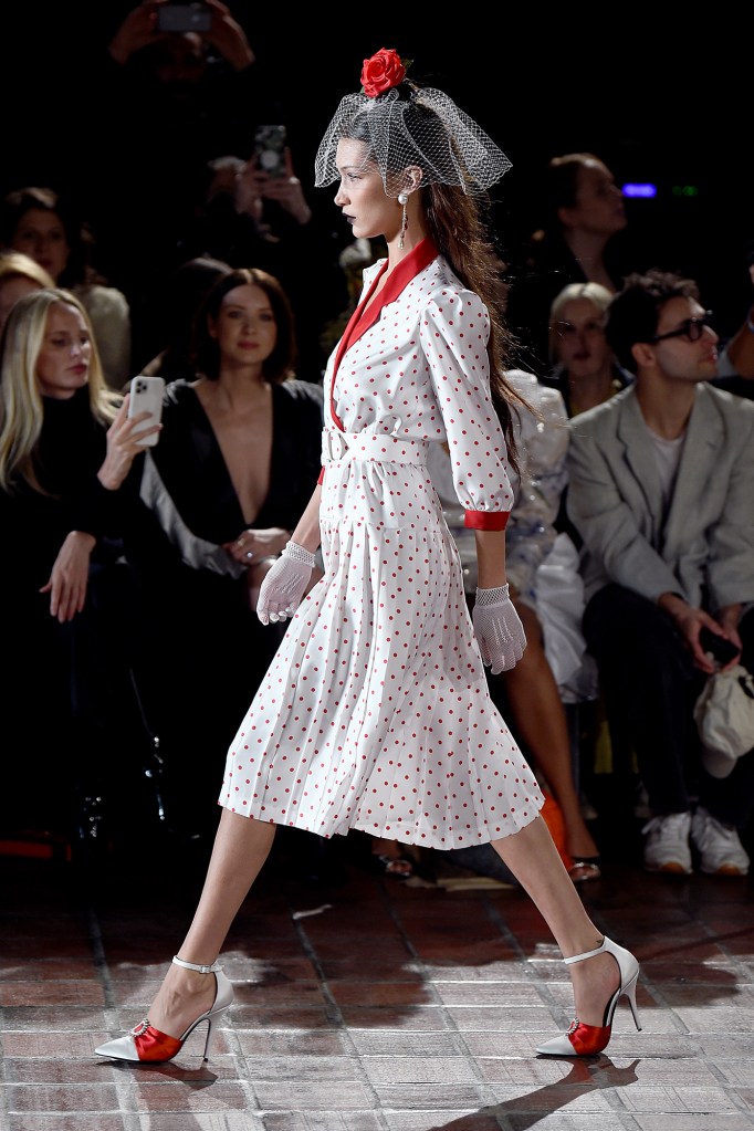 Bella Haddid models a white dress with red polka dots at the Rodarte show in 2020