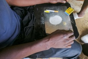 A man shows a substance known as "bombe", a mix of catalytic converters' crushed honeycomb and pills, before snorting it, in Kinshasa, Democratic Republic of the Congo August 31, 2021.