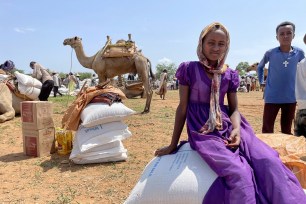 A young Tigrayan girl sits on sacks of wheat after the World Food Programme (WFP) distributed food to around 13,000 people in the rural village of Zelazle in the Tigray region of northern Ethiopia Monday, Aug. 23, 2021.