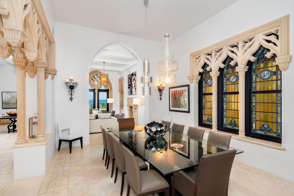 Stone tracery decorates arched stained glass windows in the dining room.