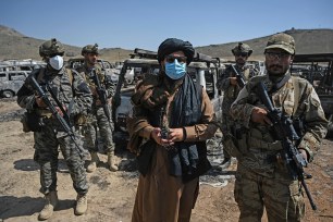 Members of the Taliban Badri 313 military unit stand beside damaged and discarded vehicles parked near the destroyed CIA base in Deh Sabz district northeast of Kabul.