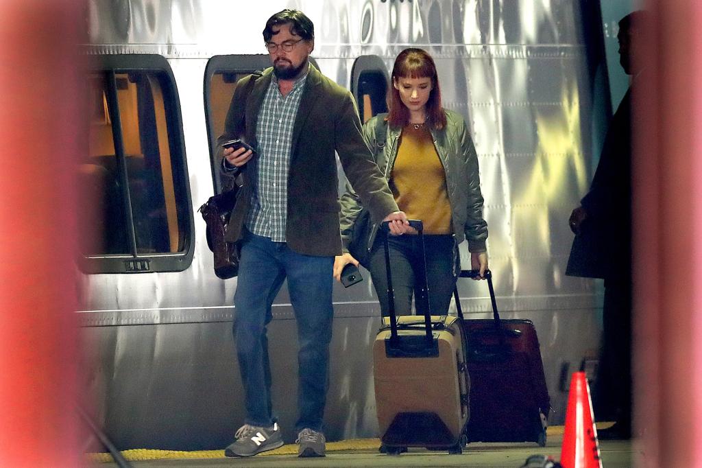 Actors Leonardo DiCaprio and Jennifer Lawrence walk along the train platform next to an Acela train at South Station during on location filming of "Don't Look Up" at South Station in Boston.