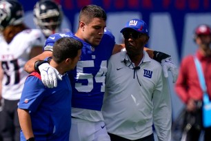 Blake Martinez gets helped off the field after suffering a knee injury on Sept. 27, 2021.