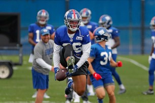 New York Giants running back Saquon Barkley #26, jumps in the air after catching a pass during practice