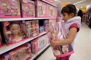 Yvette Ibarra holds a Dancing Princess Barbie doll while shopping at a toy store in Monrovia, Calif.