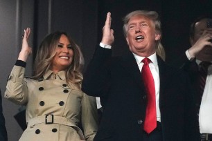 Donald and Melania Trump do the tomahawk chop with Braves fans during Game 4 of the World Series.