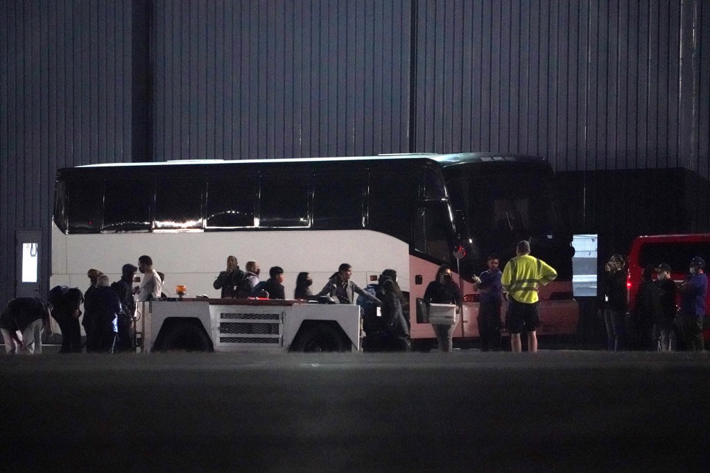 Immigrants from the southern border are seen getting off a World Atlantic Airlines airplane and boarding charter buses at Westchester County Airport. 